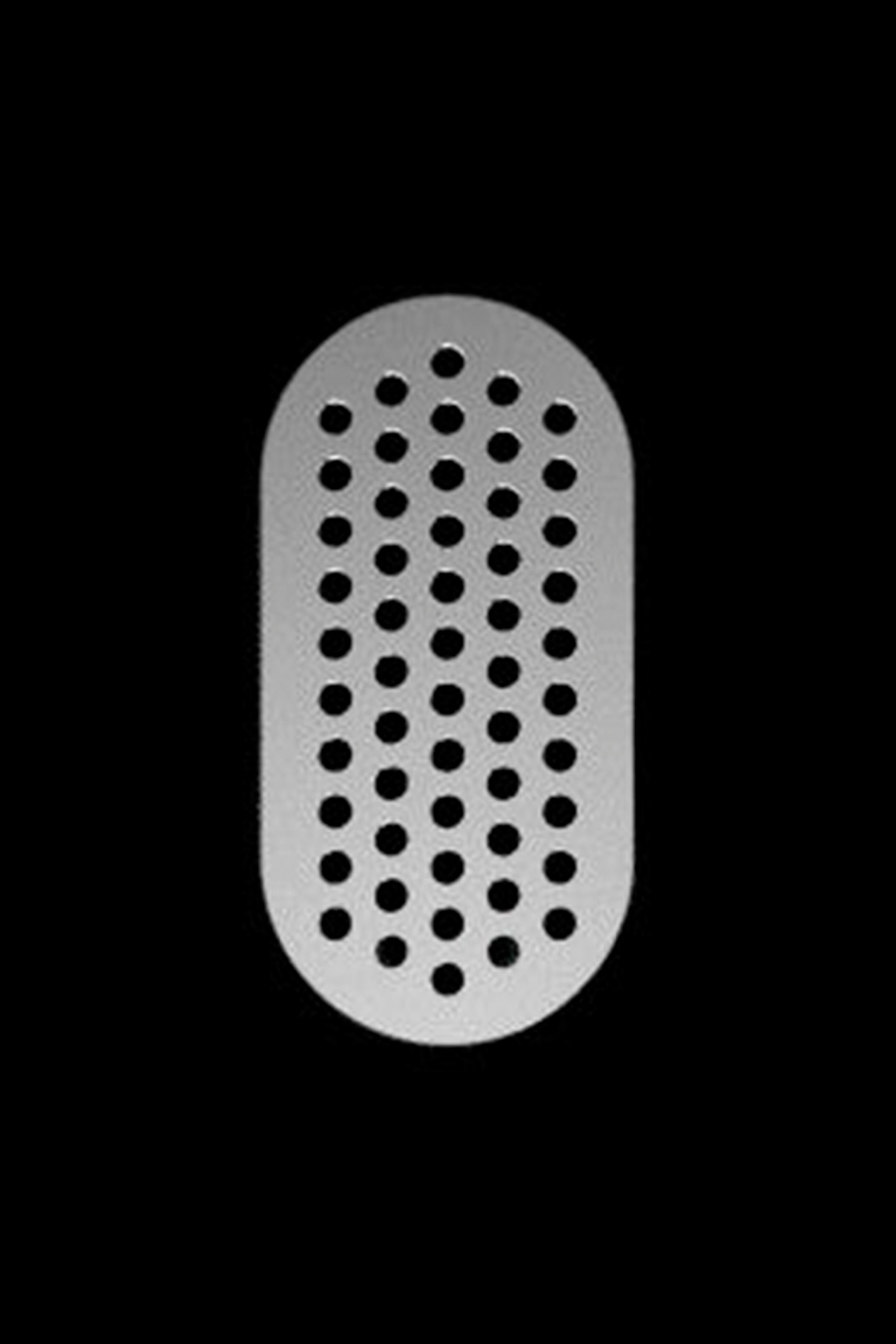 Metal herb grinder plate with numerous small holes.