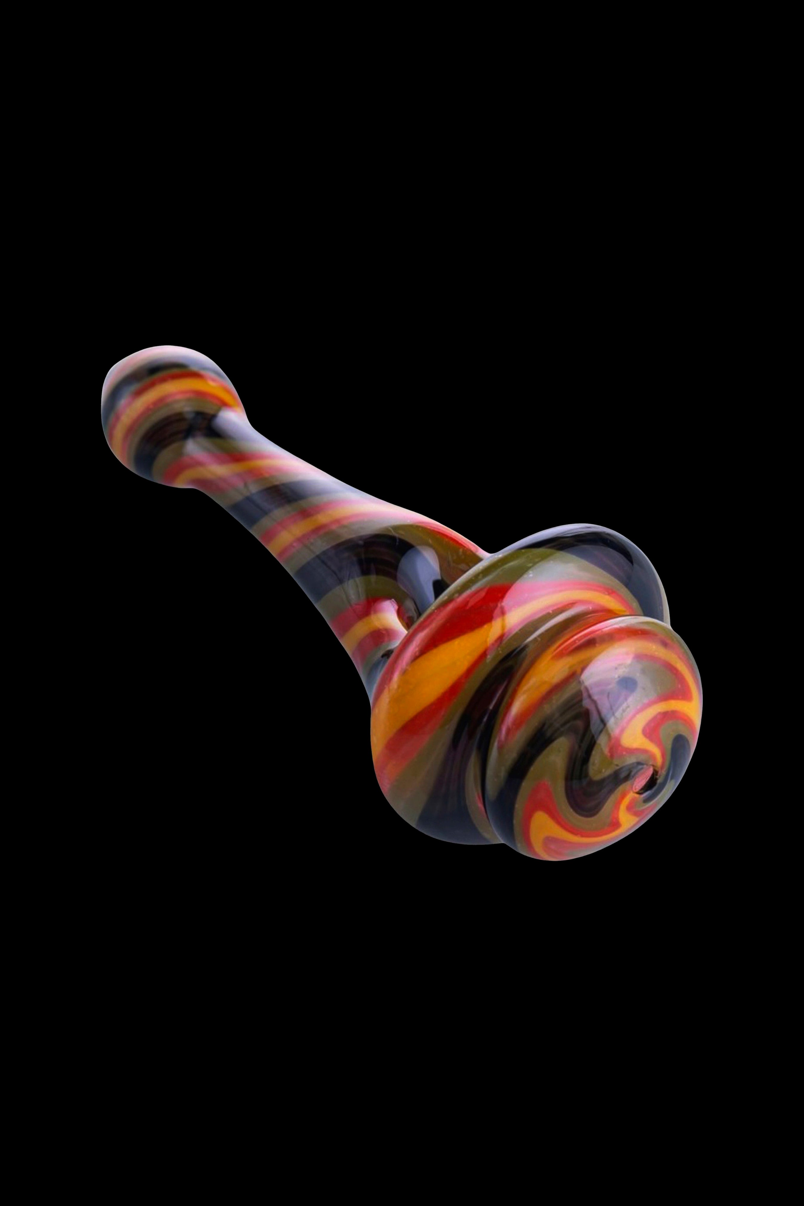 Hand-blown glass cannabis oil rig with red, orange, and black swirls against a black background.