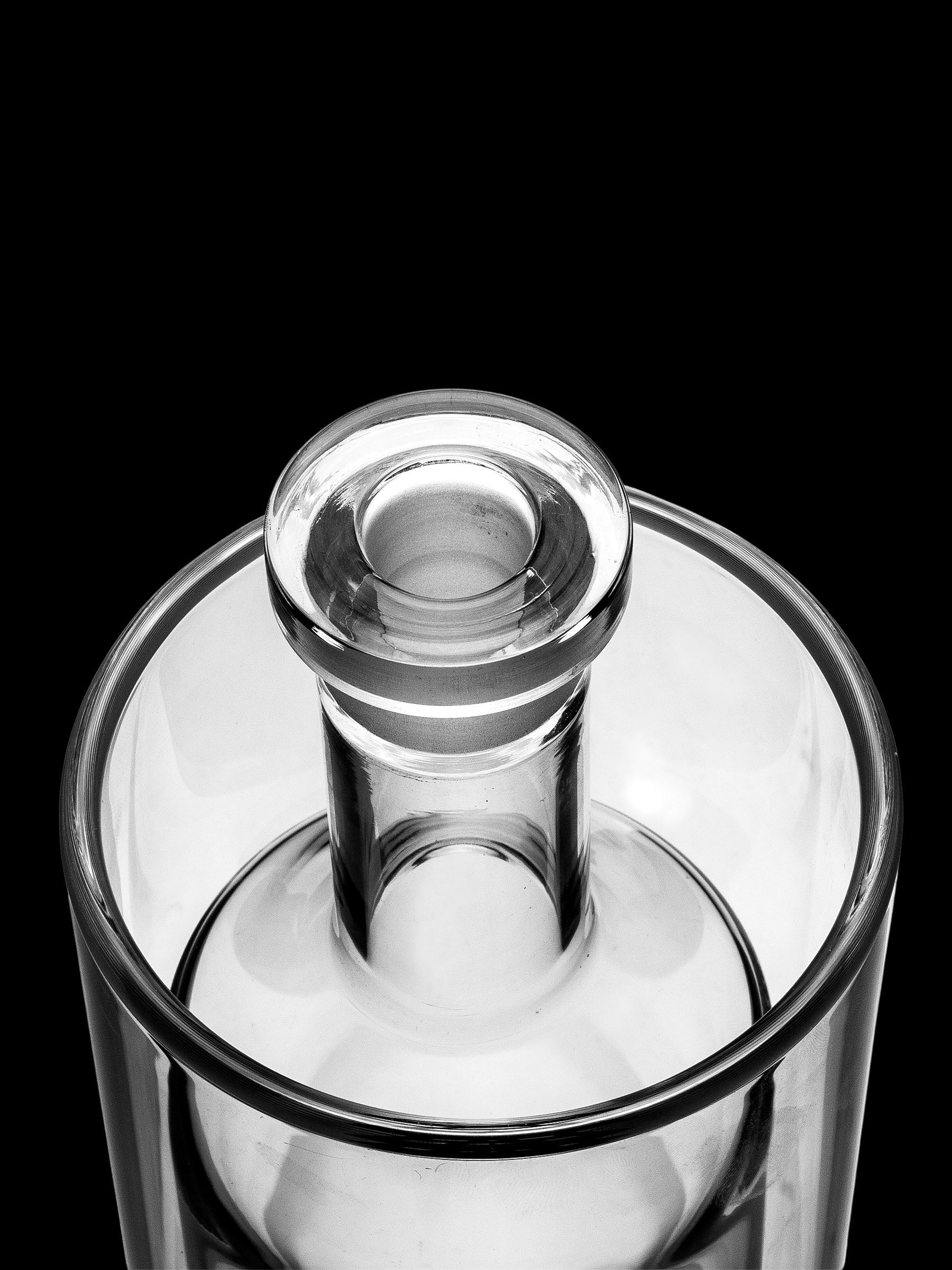 Clear glass bubbler with a removable downstem, isolated on a black background.