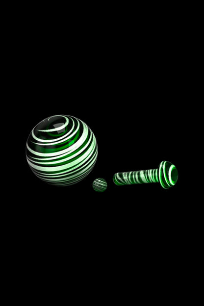 Green and white spiral glass pieces on a black background.