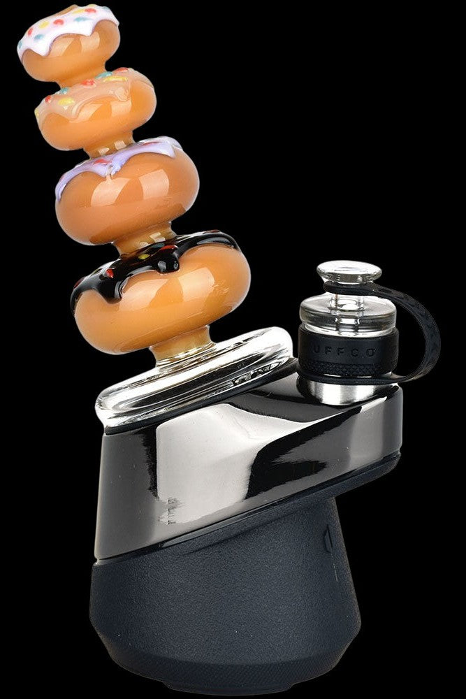 A black and silver portable vaporizer with a colorful glass bubbler attachment.