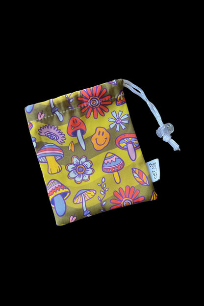 A drawstring bag with a psychedelic mushroom and floral pattern, likely used to store cannabis accessories.