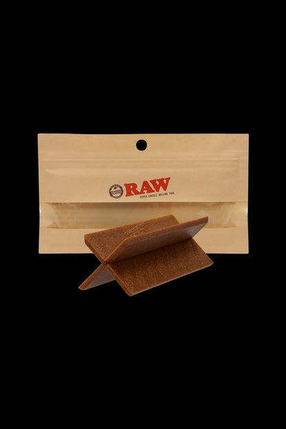 Raw paper cradle rolling tool on a beige background.