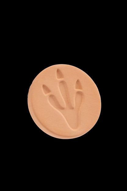 Circular cannabis-themed emblem with a leaf imprint.