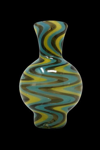 Hand-blown glass water pipe with swirling teal, yellow, and black patterns.