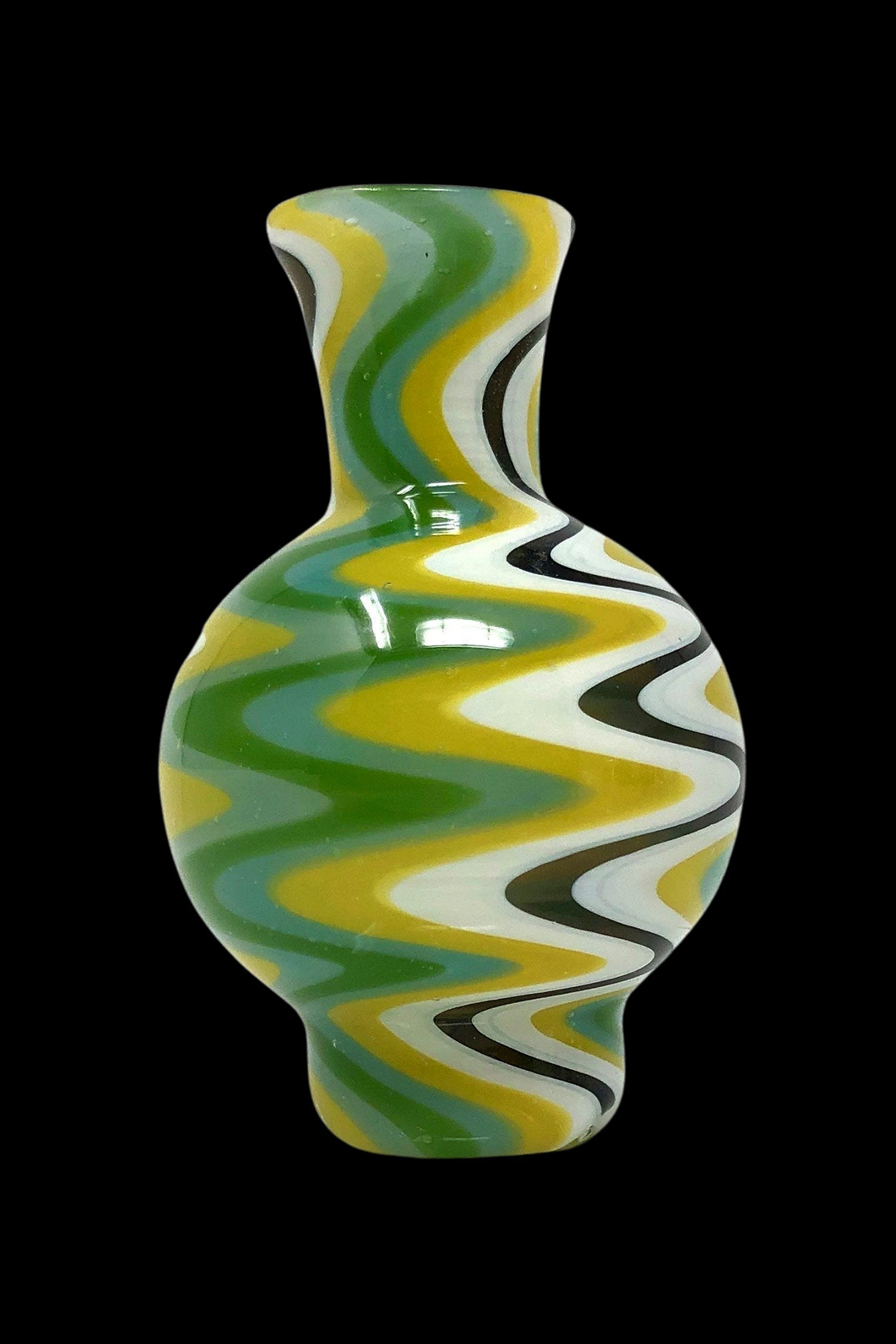 Green and yellow glass water pipe with swirling patterns against a black background.