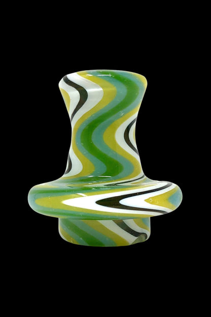 Hand-blown glass cannabis carb cap with swirling green, white, and black patterns.