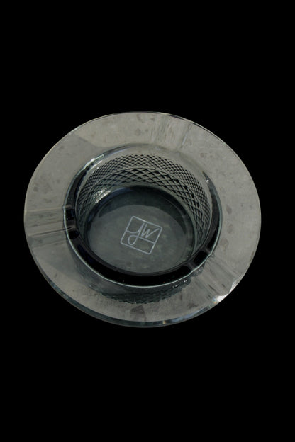 Overhead view of a clear glass ashtray with a patterned base, likely for cannabis use.