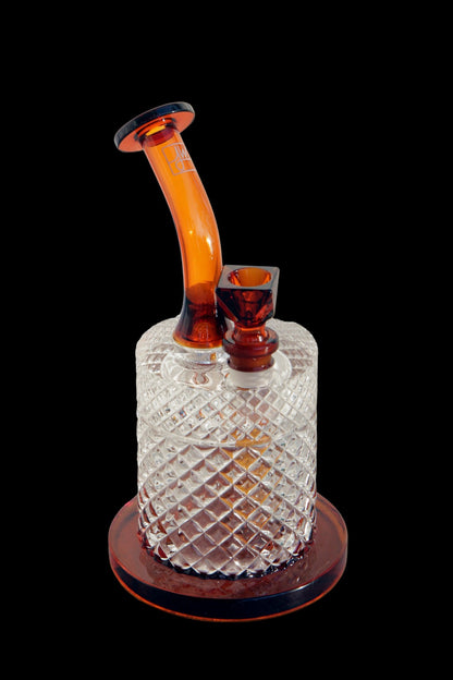 Ornate glass water pipe (rig) with geometric texture and amber accents, isolated on a black background.