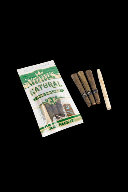 Package of King Palm Natural “Dog Walker” pre-rolled cones with three cones visible beside it, against a black background.