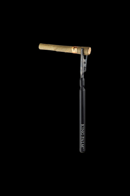 A pre-rolled cannabis blunt with a gold filter tip, displayed against a black background with “KING PALM” vertically printed on the rolling paper.
