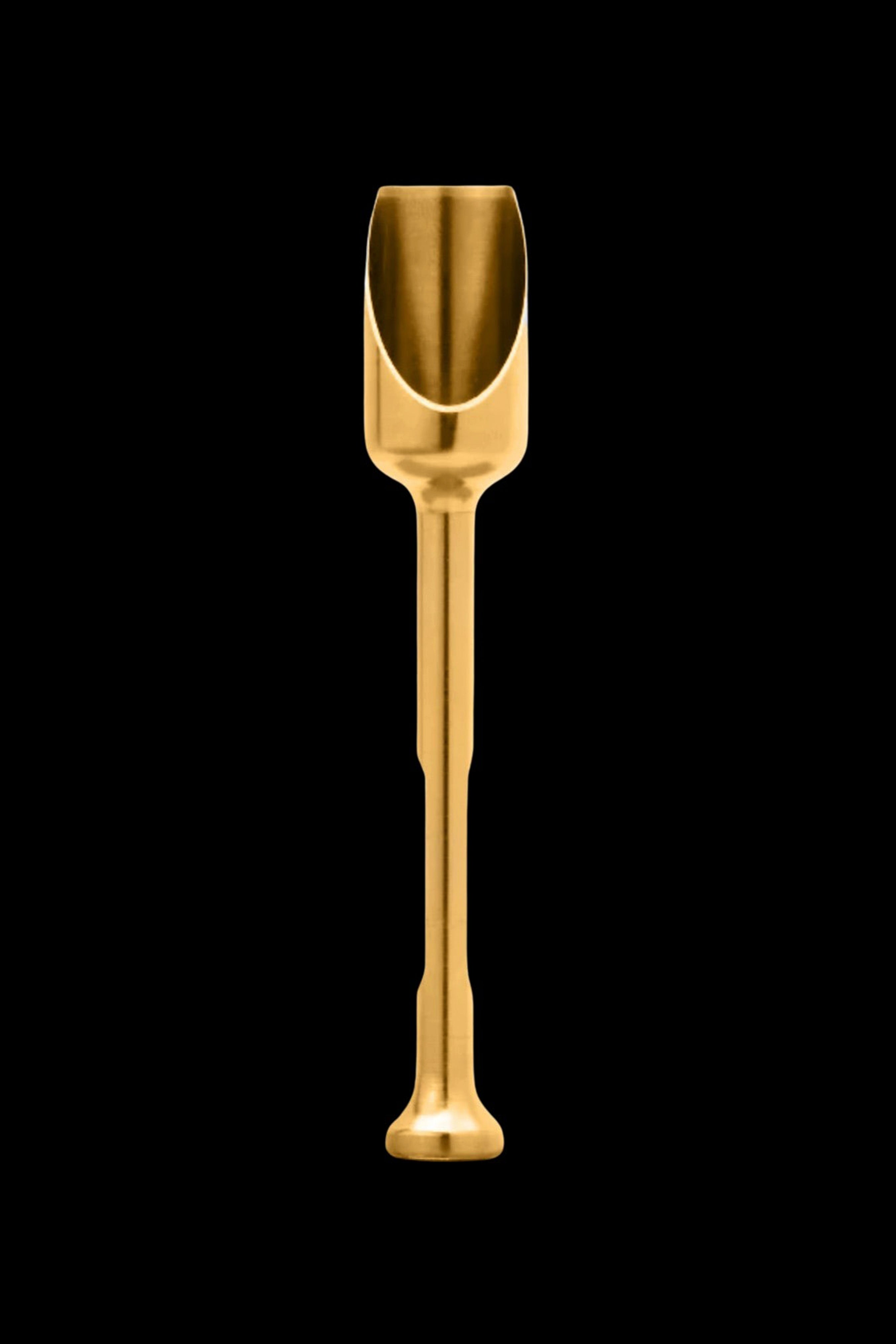 Gold cannabis scoop on black background.
