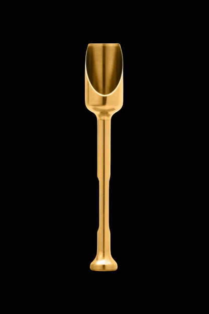 Gold cannabis scoop on black background.