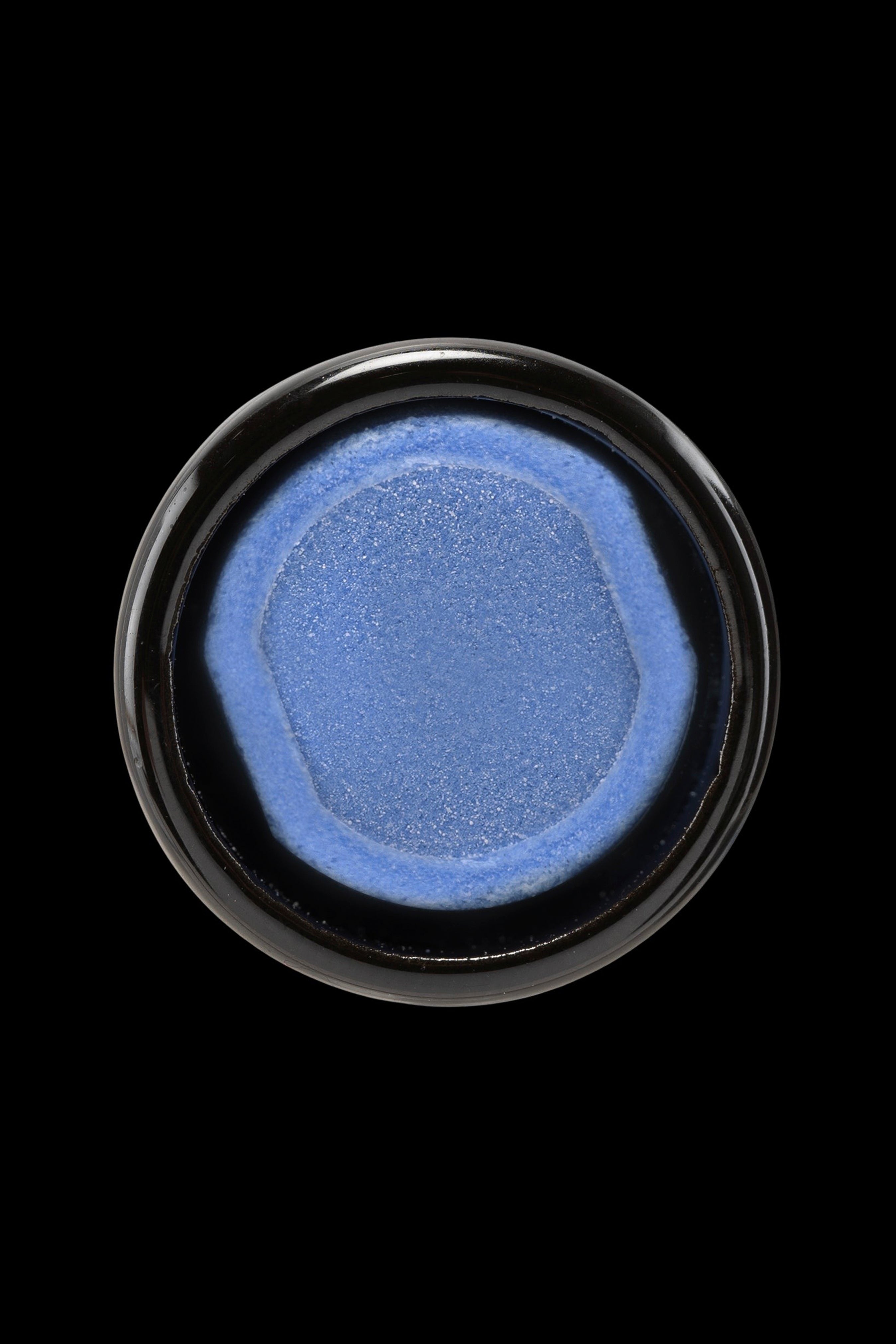 Blue cannabis concentrate in a small glass jar.