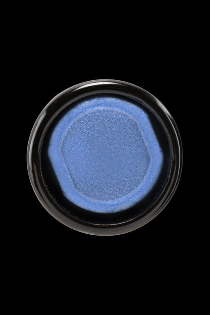 Blue cannabis concentrate in a small glass jar.