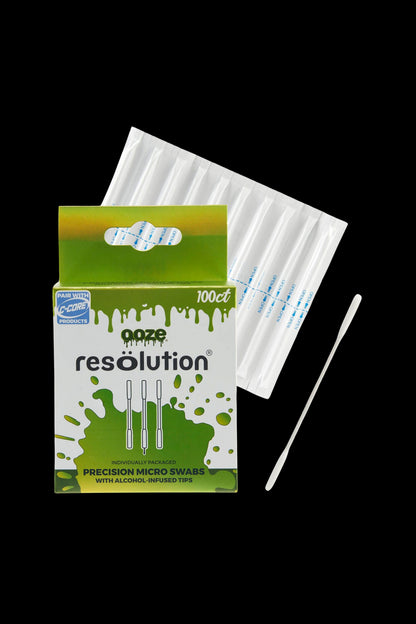 Close-up front view of the green-and-white box and individually wrapped swabs of Ooze Resolution Alcohol Micro Swabs – 100ct against a black background