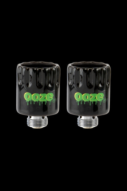 Two black glass cartridges with the “Ooze” logo in green, displayed against a black background.