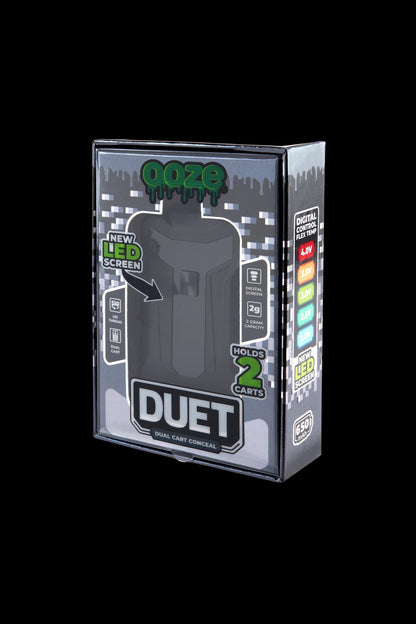 Angled front view of the boxed Ooze Duet 510 Dual Conceal Cart Battery showing the gray packaging window, logo and side LED voltage strip.