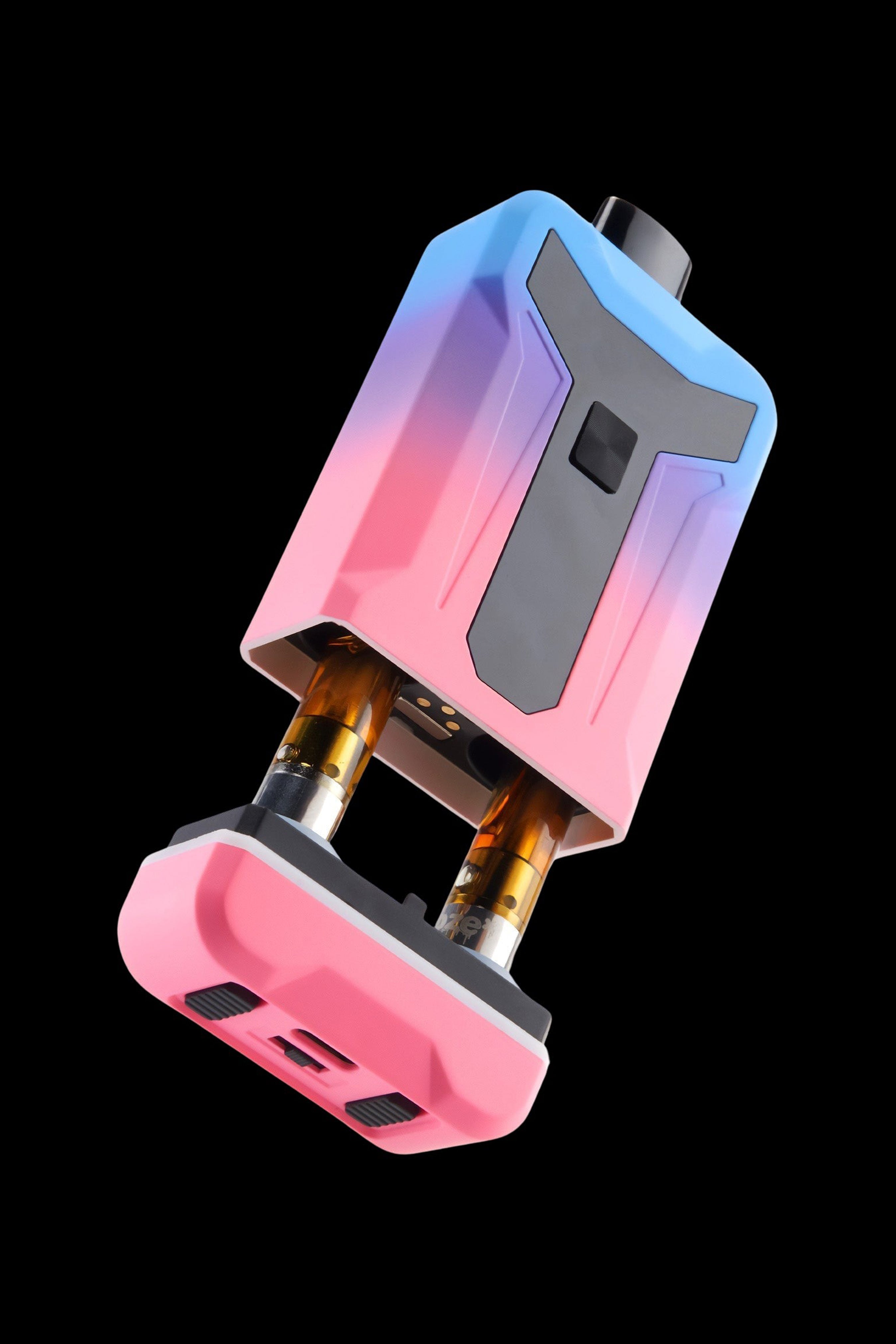 Angled close-up of the pink-to-blue gradient Ooze Duet 510 Dual Conceal Cart Battery showing dual cartridges and a matte black faceplate against a black background