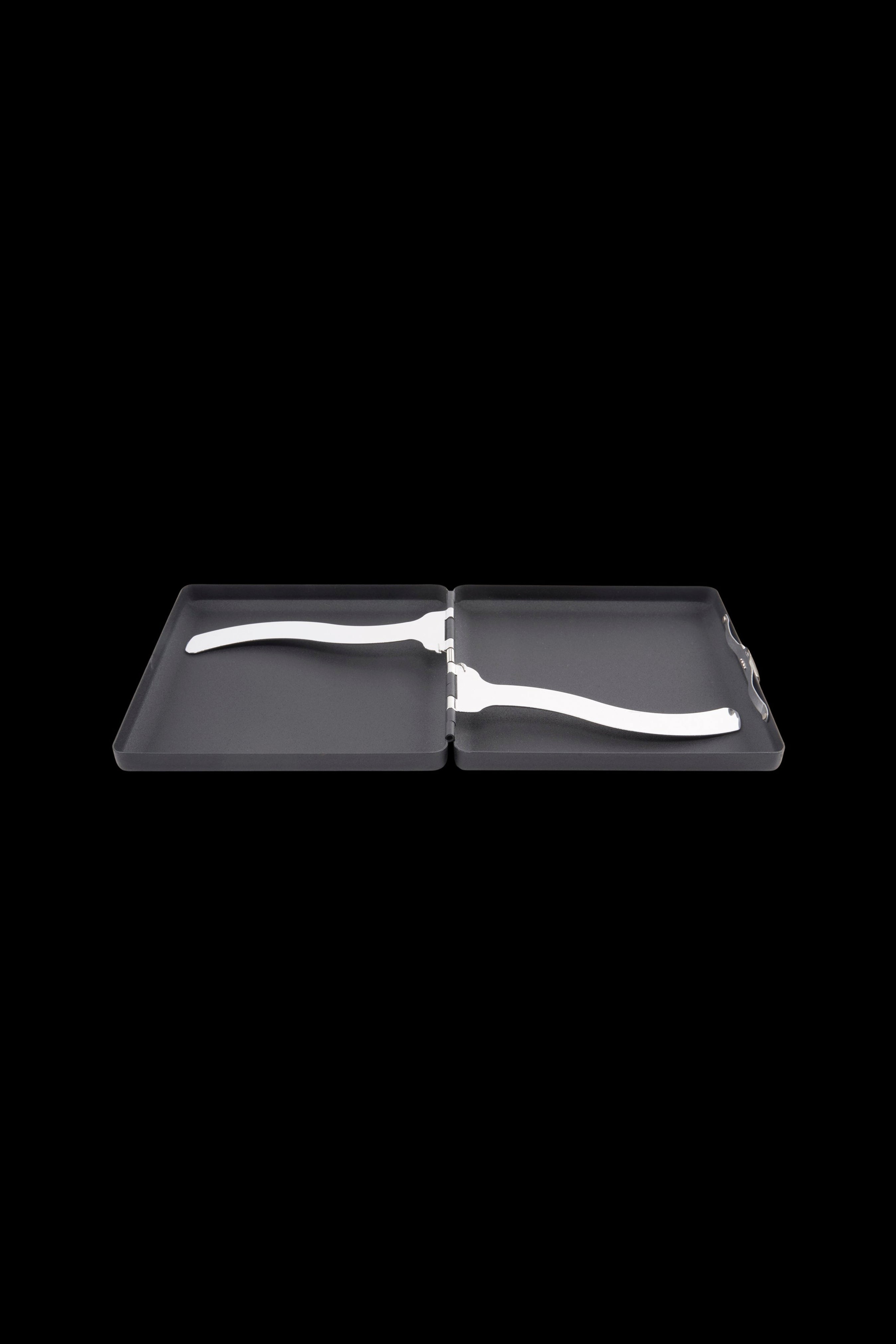 Top-down view of an open black Ooze Joint Case showing its hinged interior and two white curved metal clips against a black background