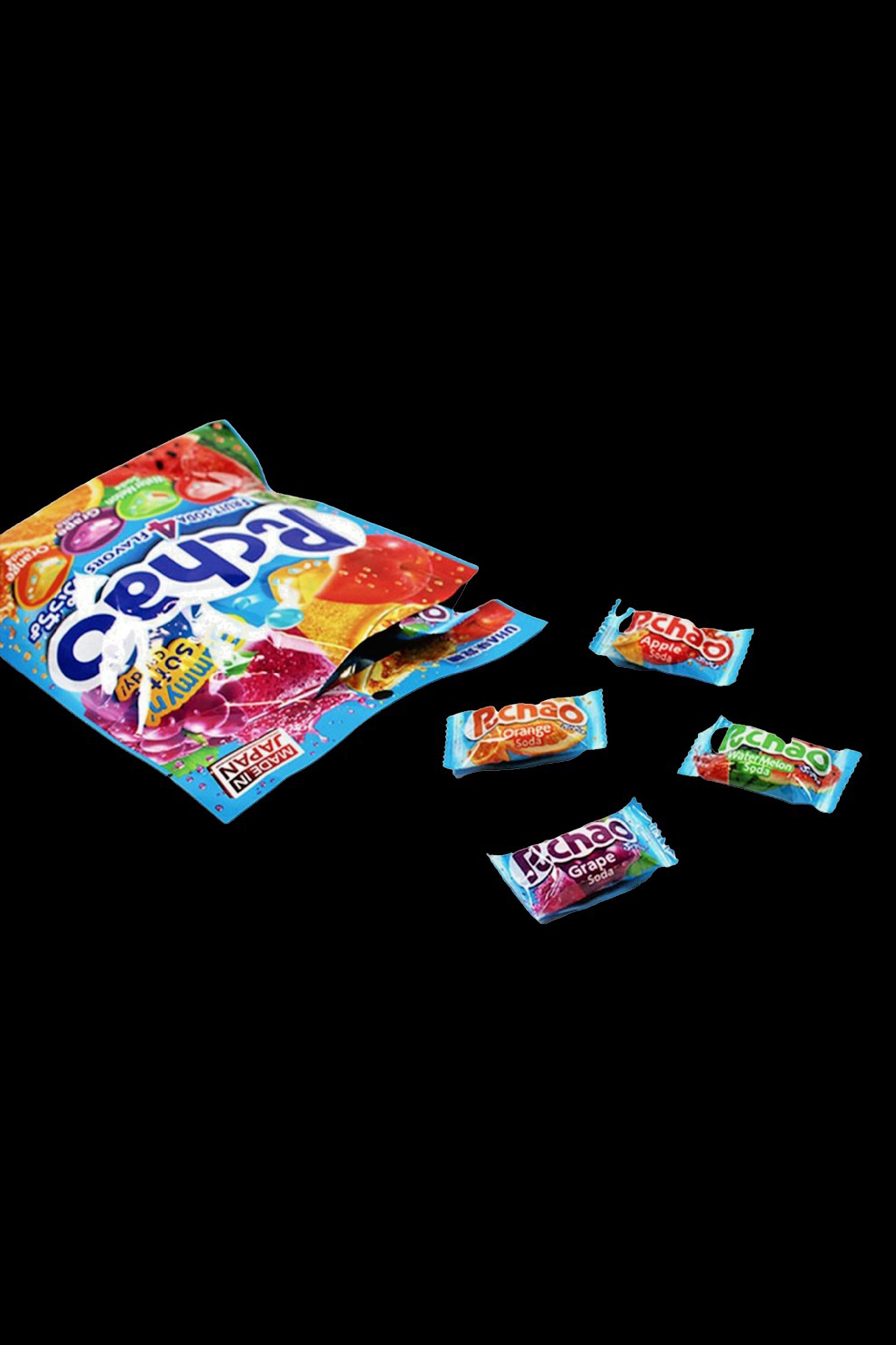 Pouch of Pez candy and individual candies scattered on a dark background, potentially referencing cannabis packaging or edible forms.