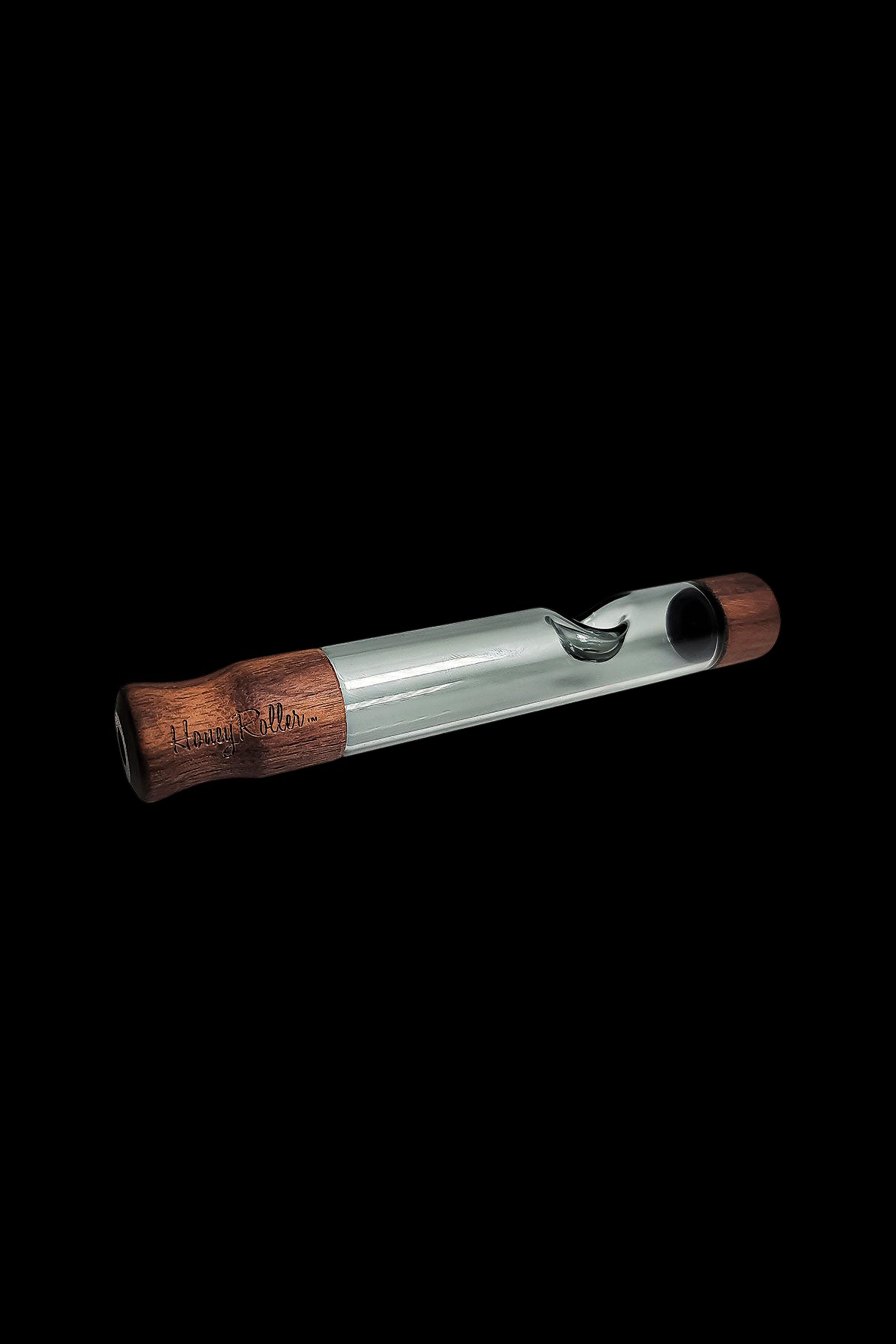 Wooden glass pipe with engraved text on a black background.