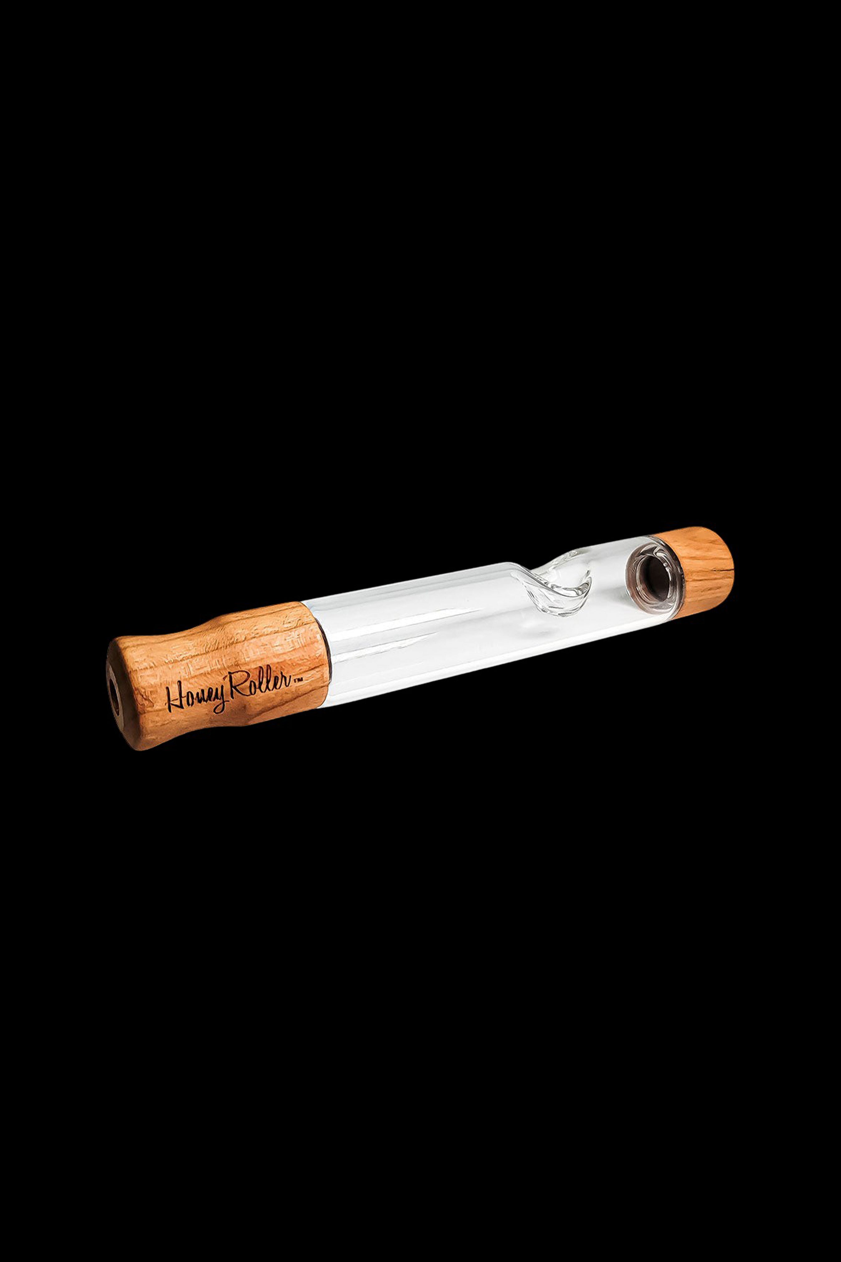 Wooden and glass one-hitter pipe with "Honey Roller" branding against a black background.