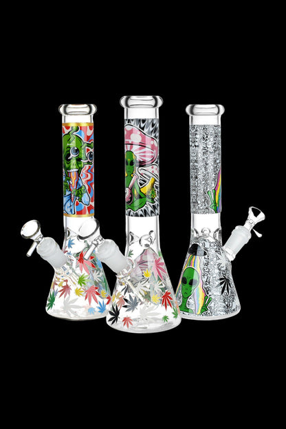 Three decorated glass bongs with cannabis leaf and alien designs against a black background.