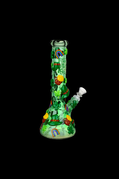 Green glass water pipe decorated with St. Patrick’s Day themed imagery, including leprechauns, shamrocks, and a rainbow, against a black background.