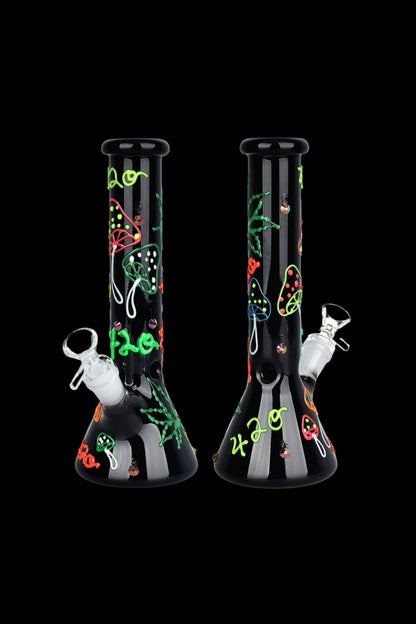 A black glass bong decorated with glowing green and red cannabis-themed designs, including leaves, eyes, and “420” text, against a black background.