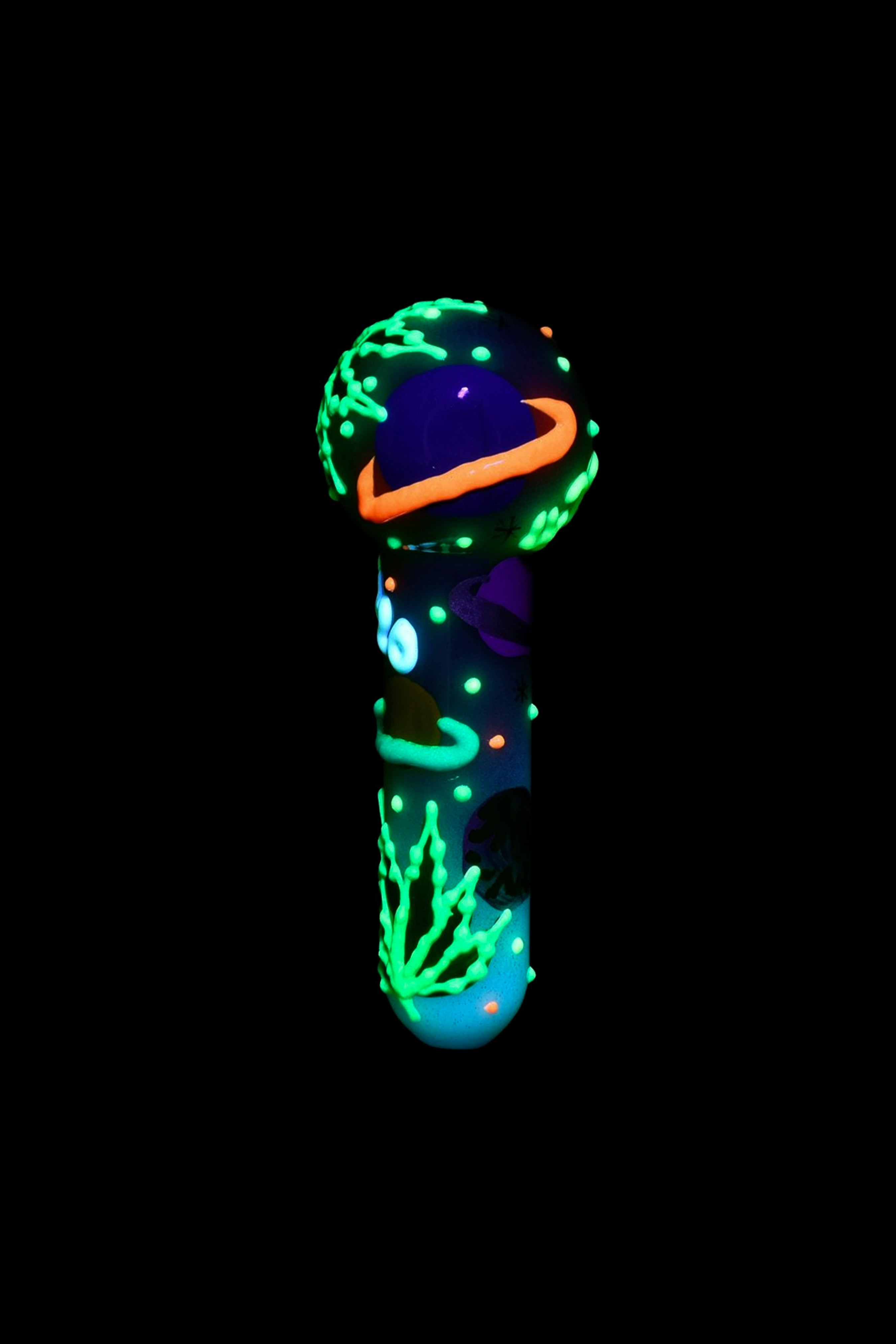 Glow-in-the-dark glass water pipe against a black background.