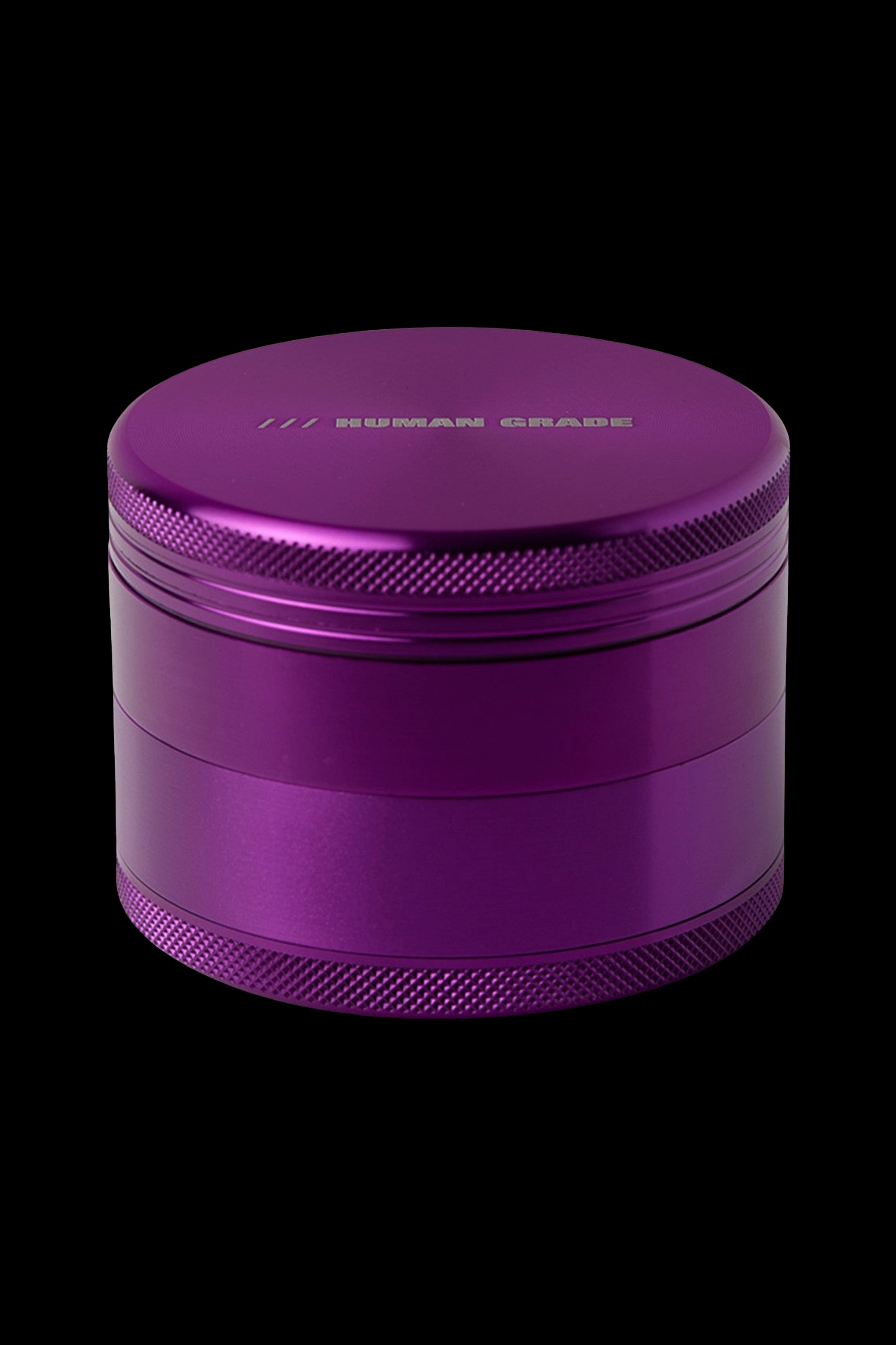 Purple four-piece cannabis grinder with textured grip.