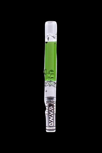 Glass cannabis oil rig with green accents and a skull design, isolated on a black background.