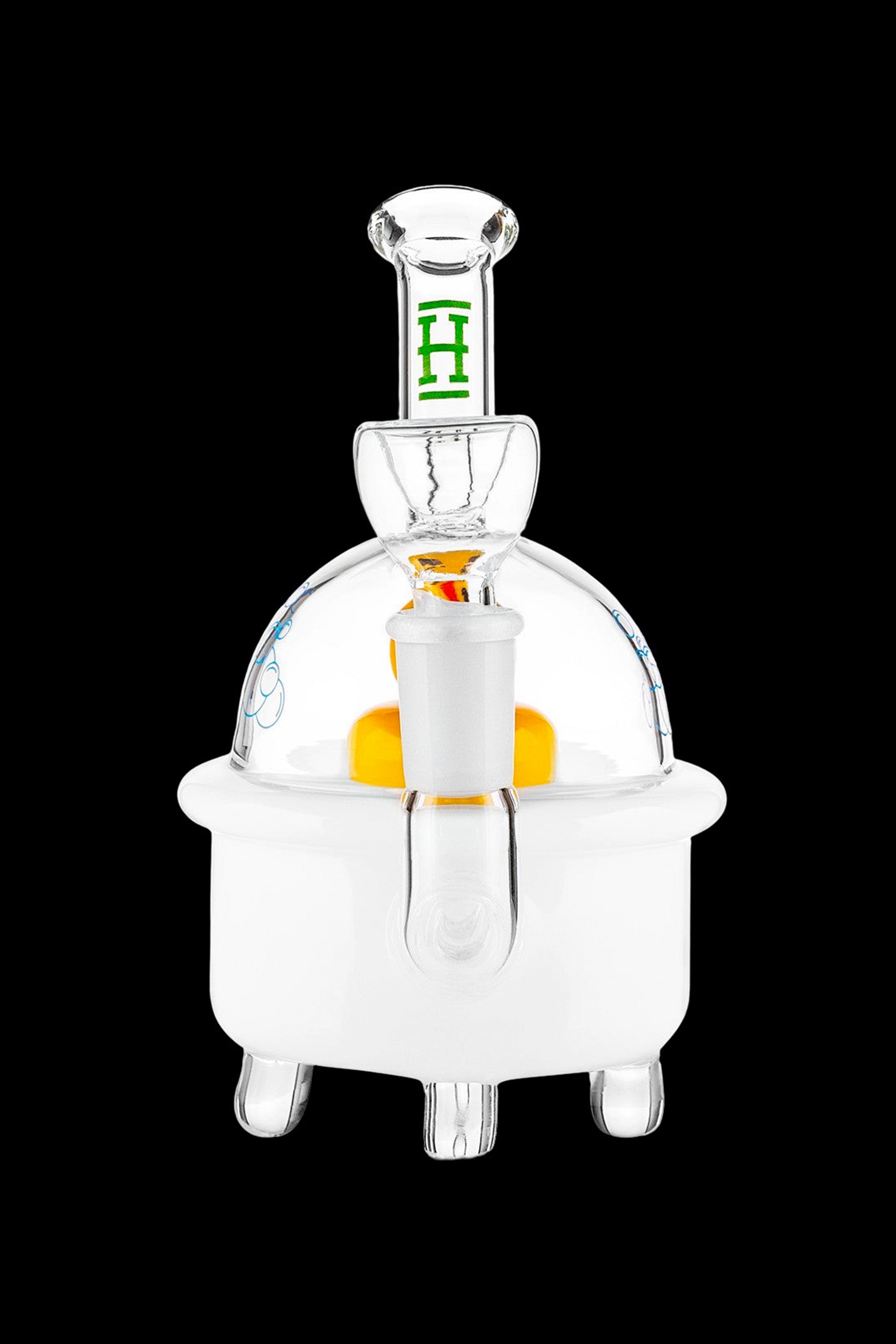 Clear glass dab rig with orange accent and green detailing, isolated on a black background.