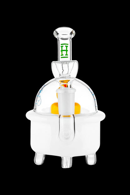 Clear glass dab rig with orange accent and green detailing, isolated on a black background.