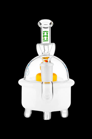 Clear glass dab rig with orange accent and green detailing, isolated on a black background. - Hemper Ducky Bong