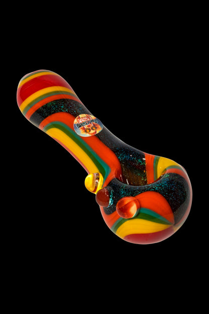 Hand-blown glass pipe with vibrant red, yellow, and green stripes against a black speckled background.