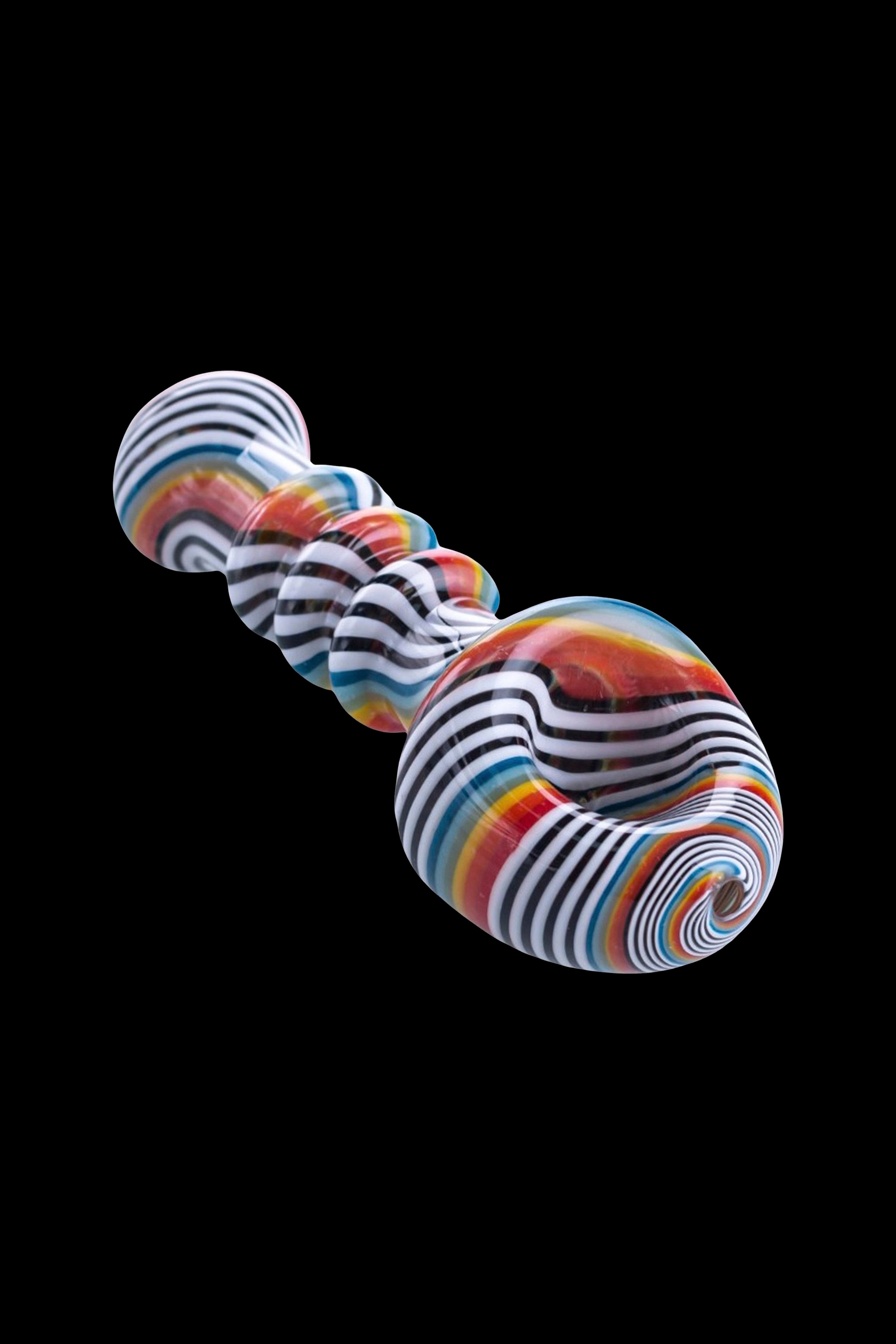 Colorful glass pipe with swirling stripes against a black background.