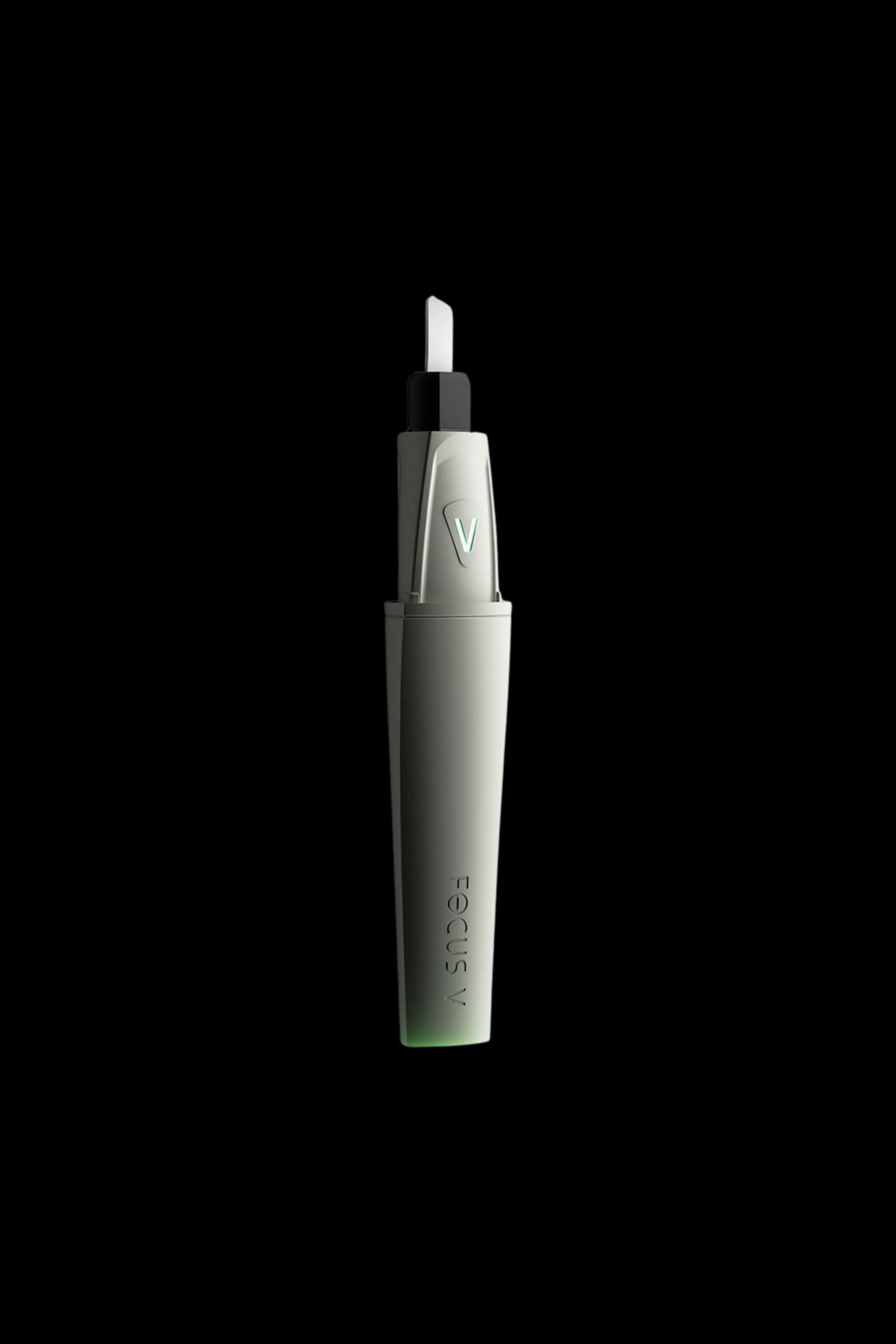 Green cannabis dab pen with white tip against a black background.