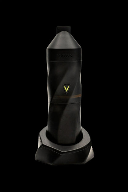 Black cannabis vaporizer pen standing in a charging base.