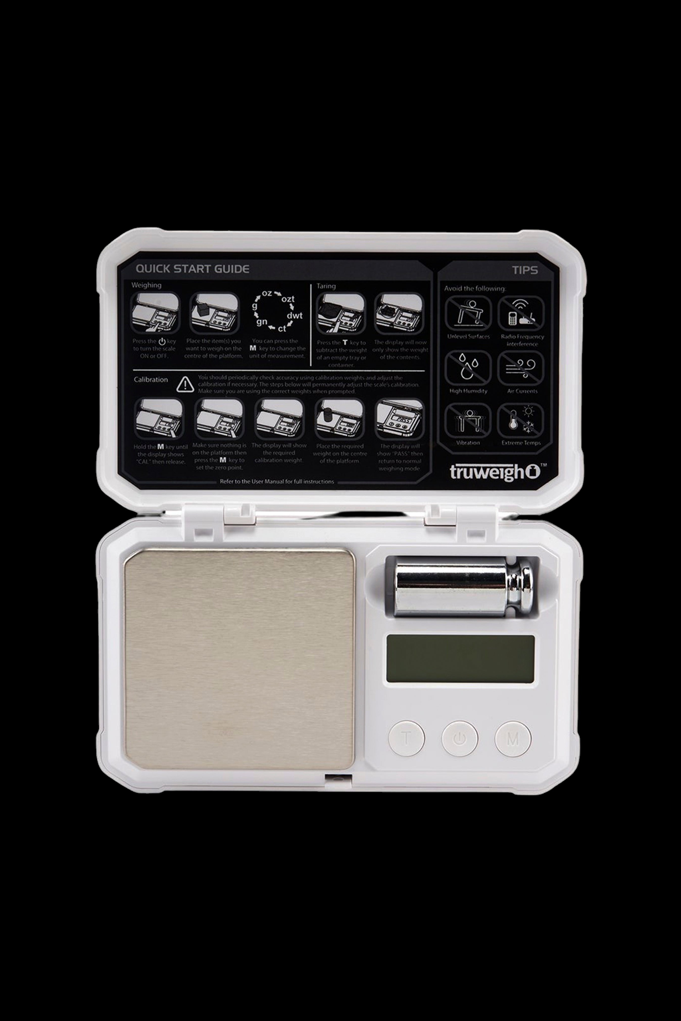 Digital scale with an open lid, displaying a quick start guide and unit conversions, commonly used for measuring cannabis.