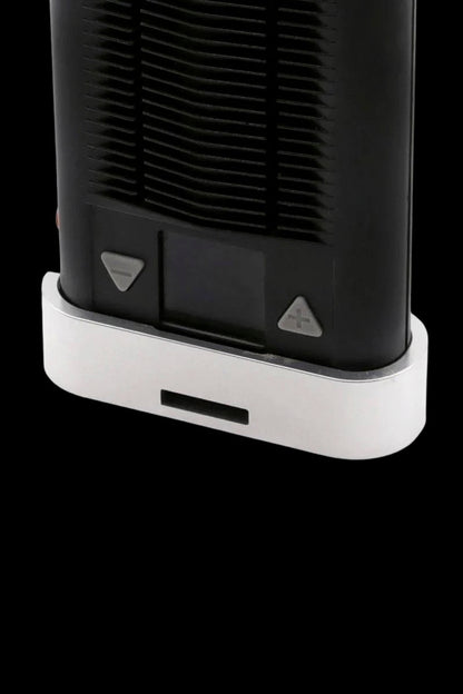 Close-up of the base of a sleek, black cannabis vaporizer with white accents and control buttons.