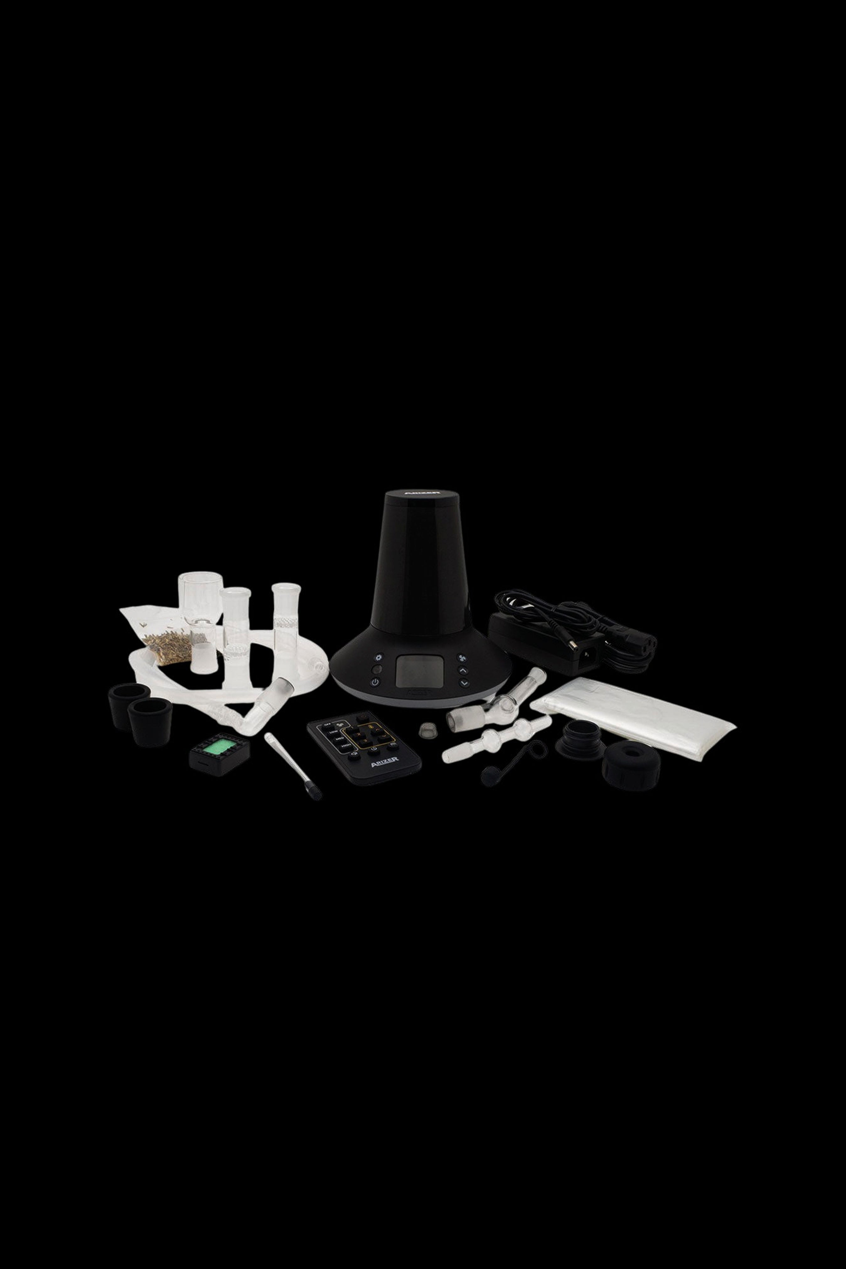 Cannabis vaporizer device and accessories displayed on a black surface.