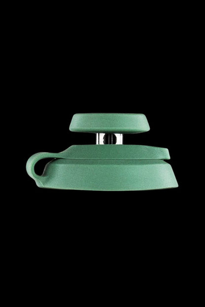 Green silicone cannabis oil container with a metal hinge and clasp.