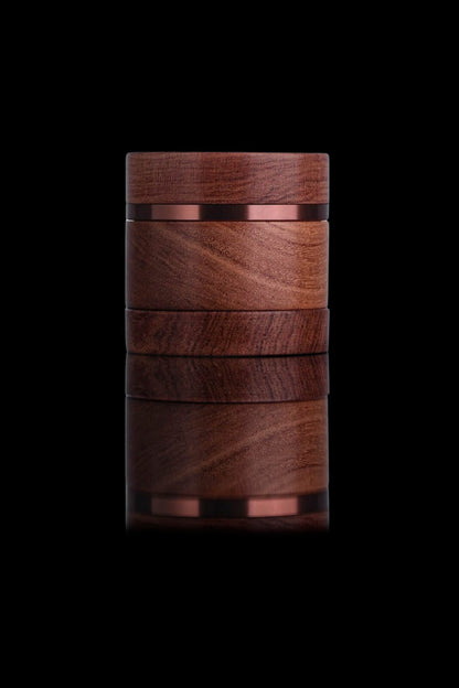 Dark wood cannabis storage jar with metallic bands, isolated on a black background.