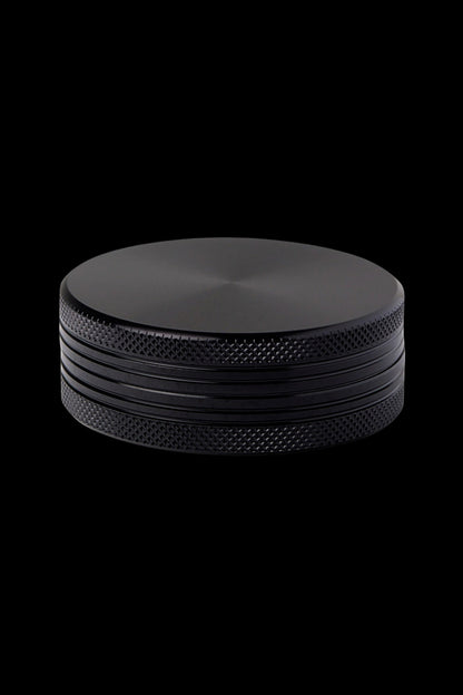 Black metal cannabis grinder on a black background.