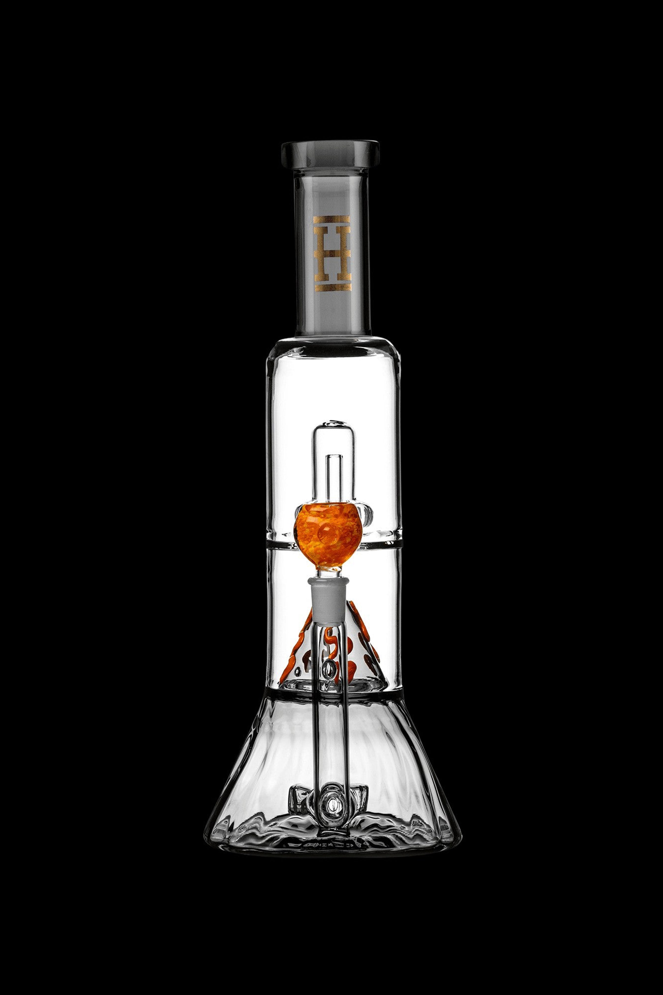 Clear glass water pipe (bong) with orange accents and intricate internal filtration system, isolated on a black background.