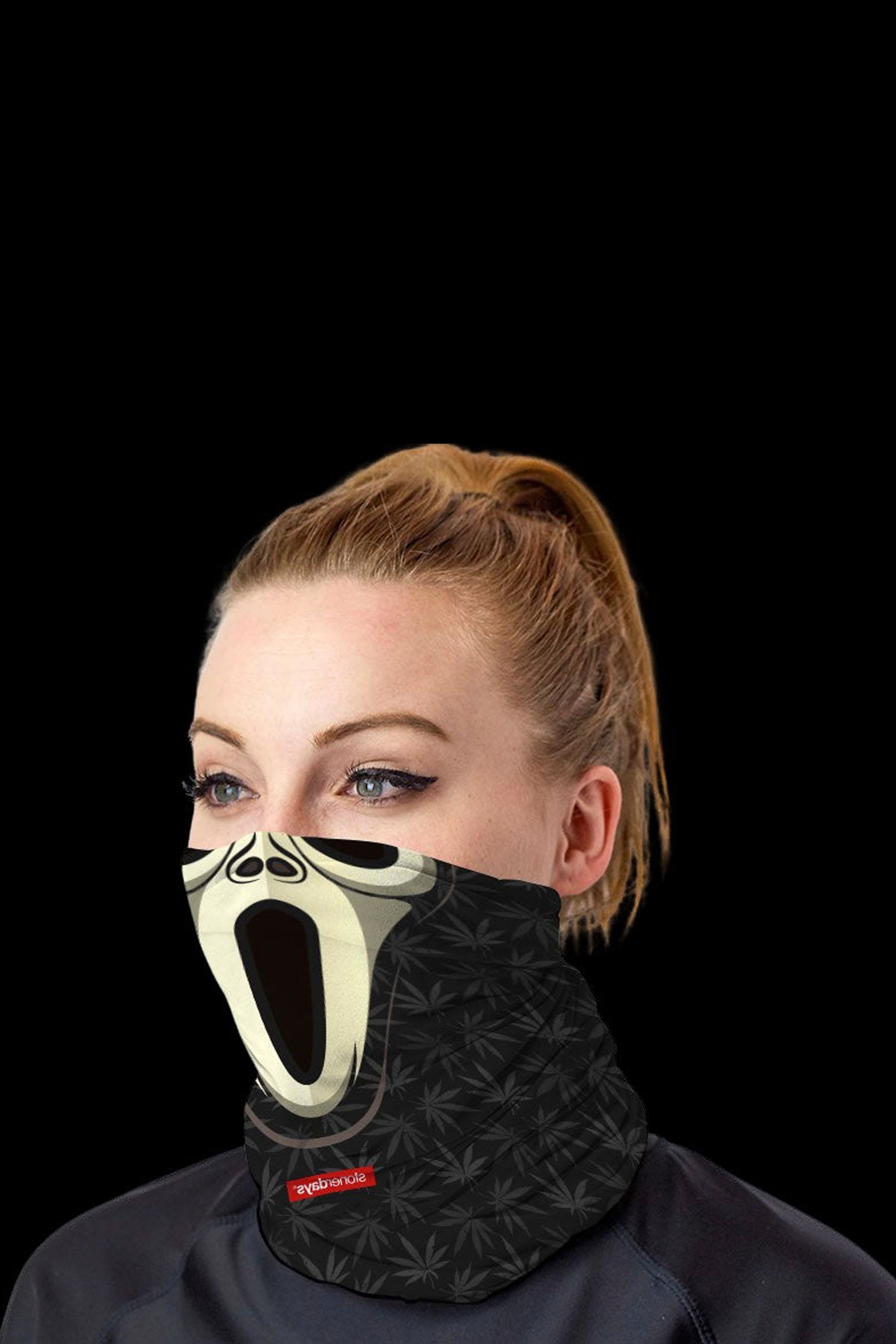 Woman wearing a black cannabis-leaf patterned neck gaiter featuring the “Scream” mask design.