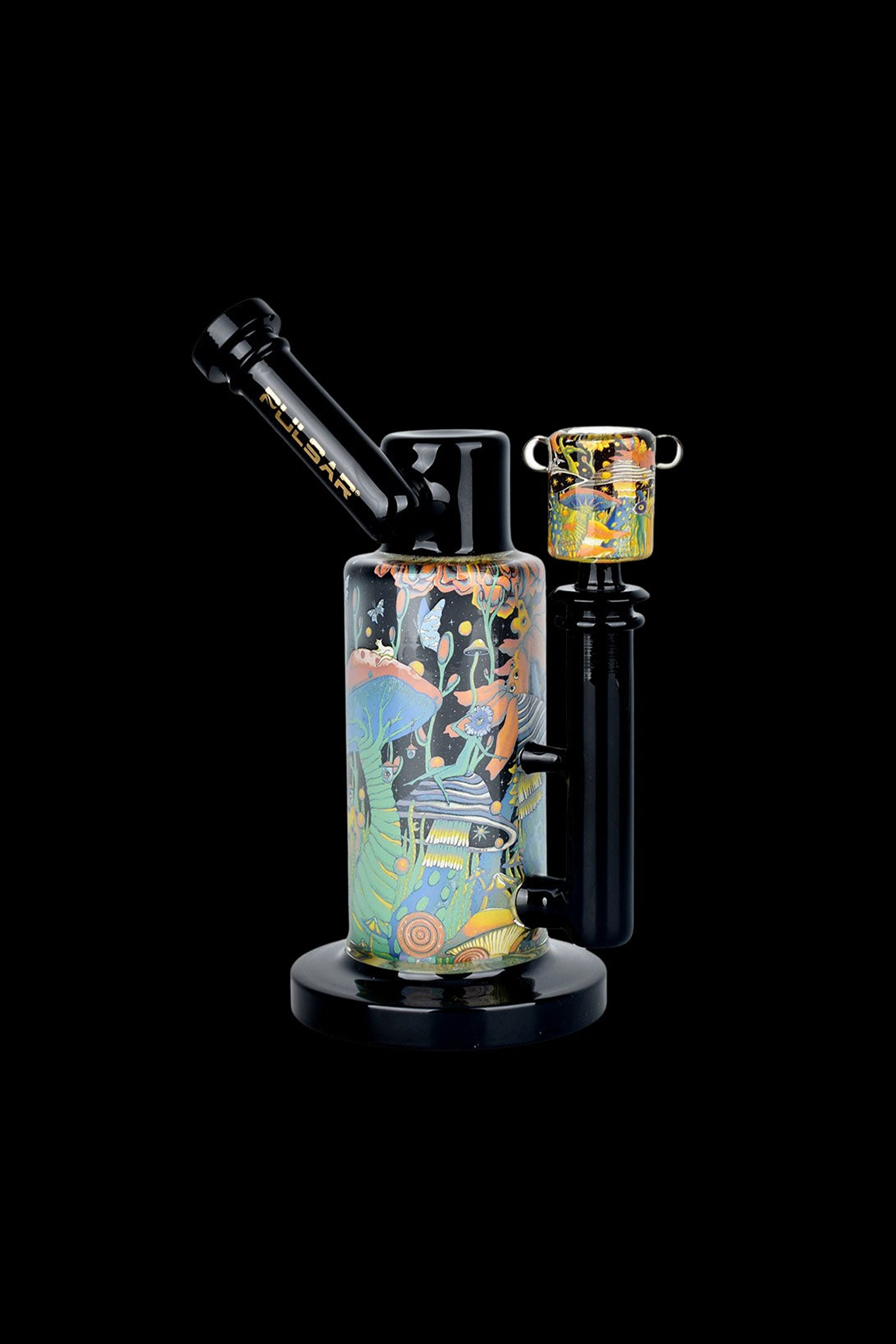 A vibrant glass water pipe (bong) with a desert-themed design, featuring cacti, mountains, and wildlife, paired with a matching glass bowl, against a black background.