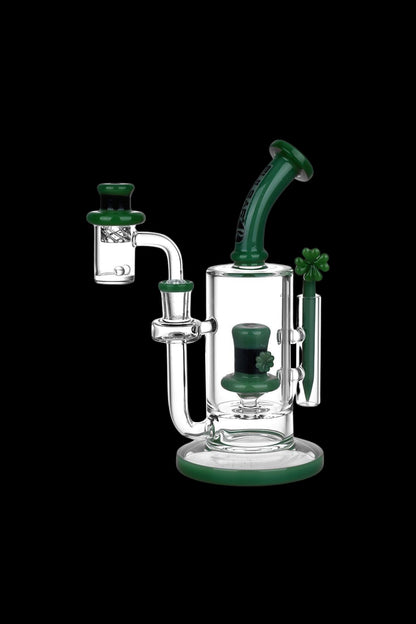 Green and clear glass dab rig with a four-leaf clover design, isolated on a black background.